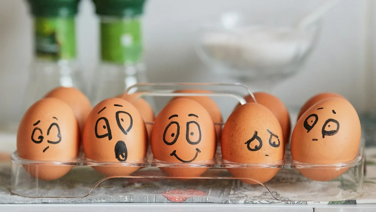 Jajka z narysowanymi minami — od uśmiechu do niepokoju, symbol skrywanych emocji